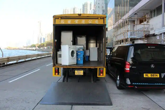 white front-load washer in yellow delivery truck